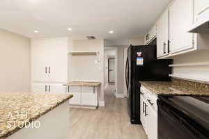 Kitchen with visible vents, under cabinet range hood, light wood-type flooring, recessed lighting, and white cabinetry