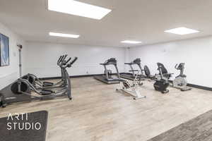 Exercise room with baseboards and wood finished floors