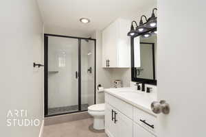 Full bath featuring vanity, tile patterned floors, toilet, and a stall shower