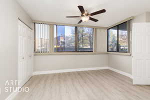 Empty room with baseboards, a ceiling fan, and wood finished floors