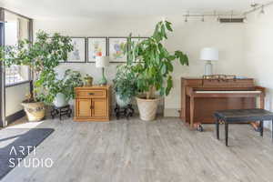 Sitting room with a healthy amount of sunlight, baseboards, and wood finished floors