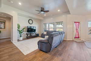 Living area featuring a healthy amount of sunlight, wood finished floors, baseboards, and ceiling fan