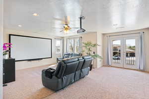 Home theater room featuring baseboards, carpet floors, recessed lighting, french doors, and a ceiling fan