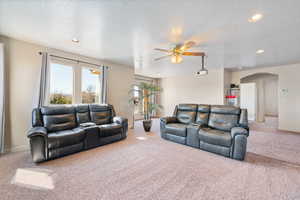 Living room featuring recessed lighting, arched walkways, carpet floors, and a ceiling fan