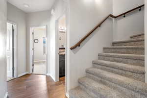 Stairway with baseboards and wood finished floors