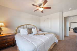 Carpeted bedroom featuring a ceiling fan and baseboards