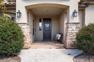 Property entrance with stone siding and stucco siding