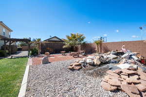 View of yard featuring a pergola and a fenced backyard