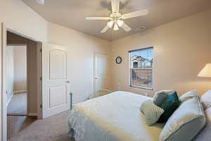 Carpeted bedroom featuring visible vents and ceiling fan