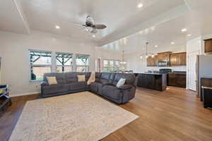 Living room with recessed lighting, ceiling fan with notable chandelier, a textured ceiling, and wood finished floors