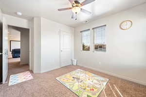 Recreation room with ceiling fan, baseboards, visible vents, and light carpet