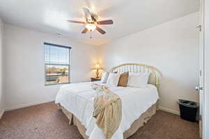 Carpeted bedroom featuring visible vents, ceiling fan, a textured ceiling, and baseboards