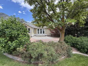 Back of property featuring french doors, stucco siding, and a patio area