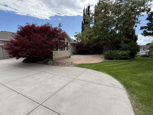View of property exterior with a lawn and a patio