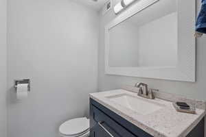 Bathroom featuring visible vents, toilet, and vanity