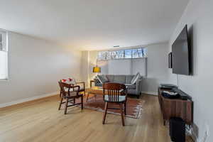 Living area with light wood finished floors and baseboards