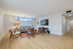 Living area with visible vents, baseboards, and light wood finished floors