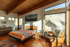 Bedroom featuring beamed ceiling, wood ceiling, and wood finished floors