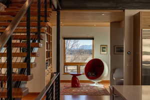 Corridor featuring stairway, baseboards, and wood finished floors
