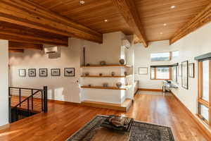 Interior space featuring beam ceiling, light wood-style floors, wooden ceiling, and a wall mounted AC