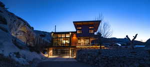 View of front of home featuring an attached garage, driveway, a balcony, stone siding, and a mountain view