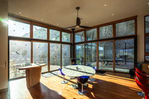 Interior space featuring a ceiling fan, wood finished floors, and floor to ceiling windows