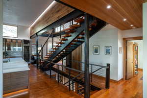 Staircase featuring recessed lighting, baseboards, and hardwood / wood-style floors