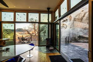 Entryway featuring a wall of windows, a mountain view, wood finished floors, and a wood stove