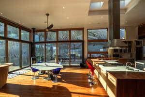 Interior space featuring a sink, a wall of windows, wood-type flooring, and ceiling fan