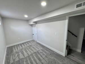 Finished below grade area featuring recessed lighting, visible vents, carpet flooring, and baseboards