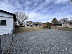 View of yard with an outbuilding, fence, and a residential view