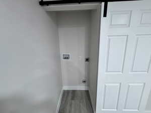 Laundry area featuring electric dryer hookup, washer hookup, baseboards, and wood finished floors