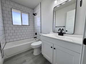Full bathroom with toilet, shower / washtub combination, wood finished floors, and vanity
