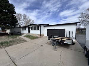 View of front of property with concrete driveway and a garage