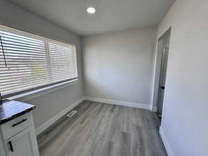 Spare room with visible vents, baseboards, and wood finished floors