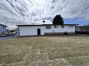 Rear view of property with a lawn