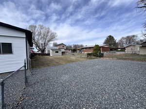 View of yard featuring a residential view, an outdoor structure, and fence