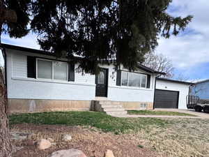 Single story home with concrete driveway, an attached garage, and brick siding