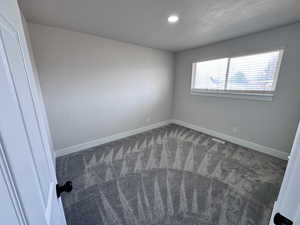 Unfurnished bedroom with visible vents, baseboards, a textured ceiling, and carpet floors