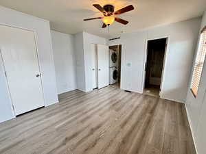 Primary Bedroom with ceiling fan. Stacked washer/dryer in view