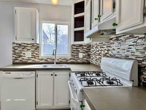 Freshly painted white cabinets, backsplash, gas range