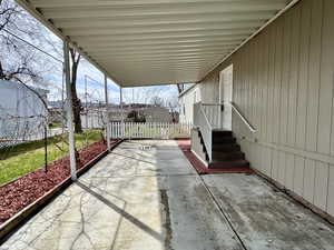 View of carport, main door, fully gated yard