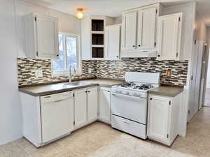 Freshly painted white cabinets, backsplash, gas range