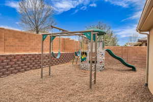 View of play area with a fenced backyard