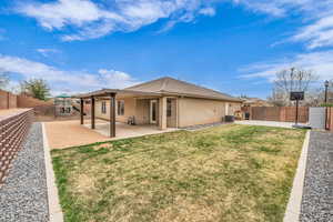 Back of property featuring stucco siding, a lawn, a fenced backyard, a playground, and a patio area