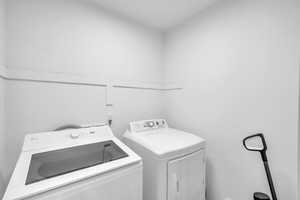 Clothes washing area featuring laundry area and washer and clothes dryer