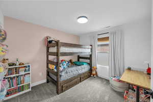 Carpeted bedroom featuring baseboards and visible vents