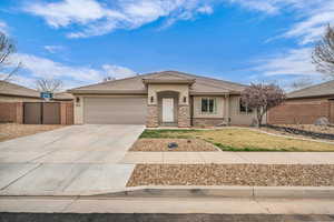 View of front of home featuring a tile roof, concrete driveway, fence, and stucco siding