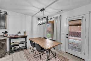 Dining room featuring light tile patterned floors, visible vents, and a chandelier