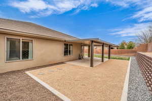 Rear view of property featuring a tiled roof, stucco siding, a fenced backyard, and a patio area